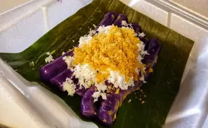 there fried rolled treats on a green ledge covered in ube, coconut, and cheese