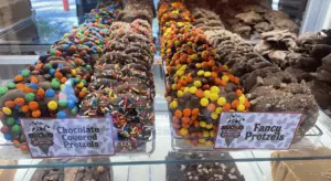 array of chocolate covered pretzels topped with Reeses Pieces and M&Ms.
