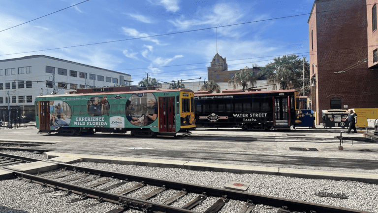 two streetcars at a station in a historic downtown area
