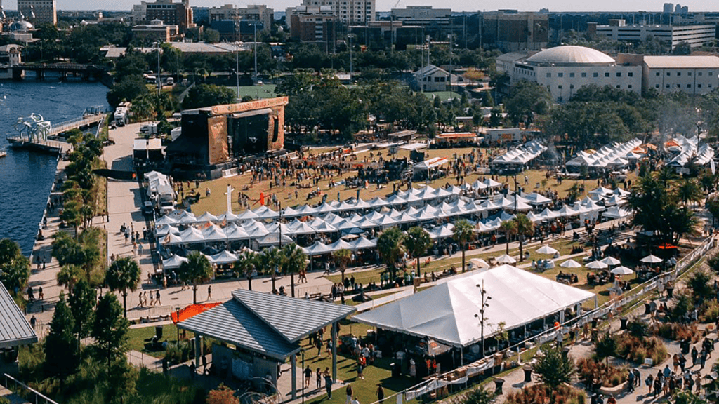 Aerial view of a waterfront park with a concert set up