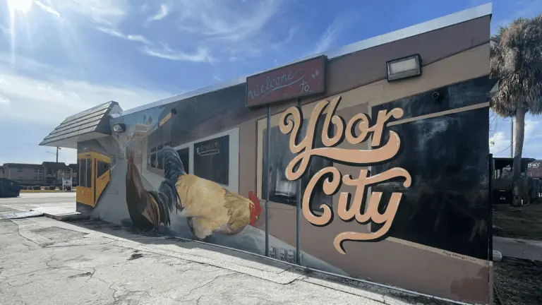 Mural featuring a rooster and "Ybor City" written in gold font on the side of a building