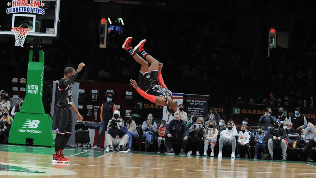 a basketball player does a back flip on the court