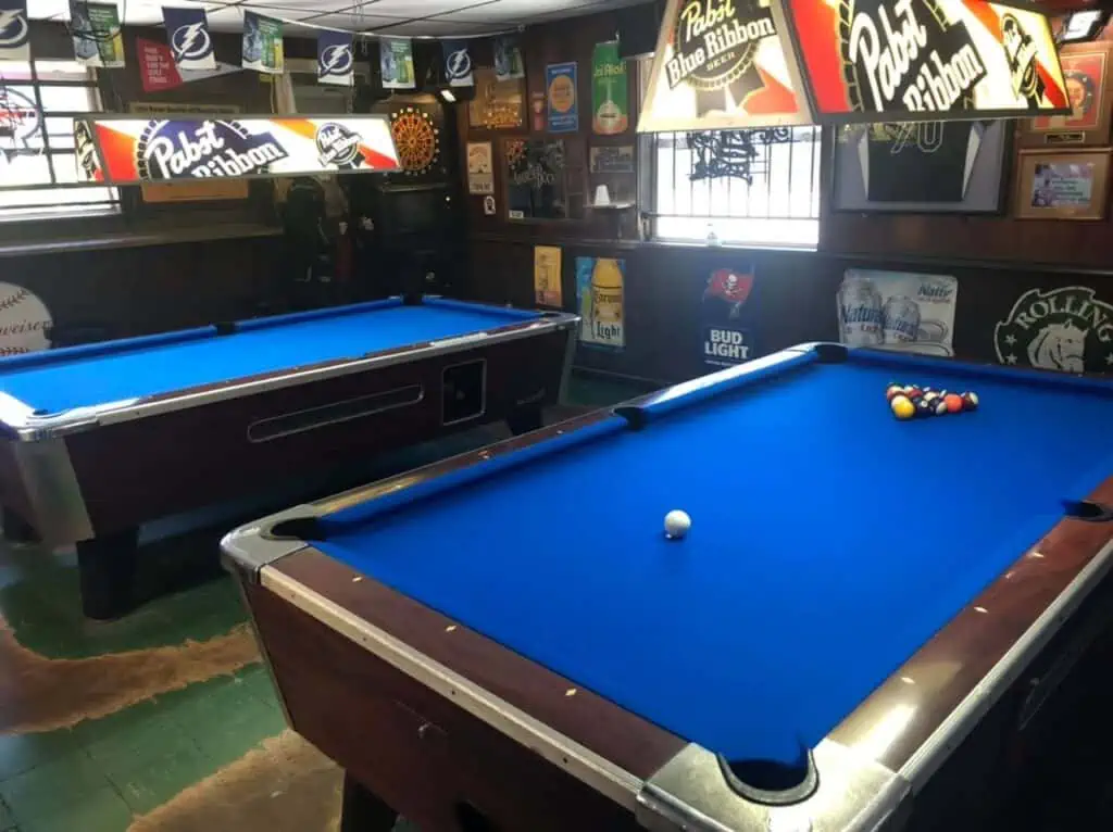 two blue pool tables set up in a bar