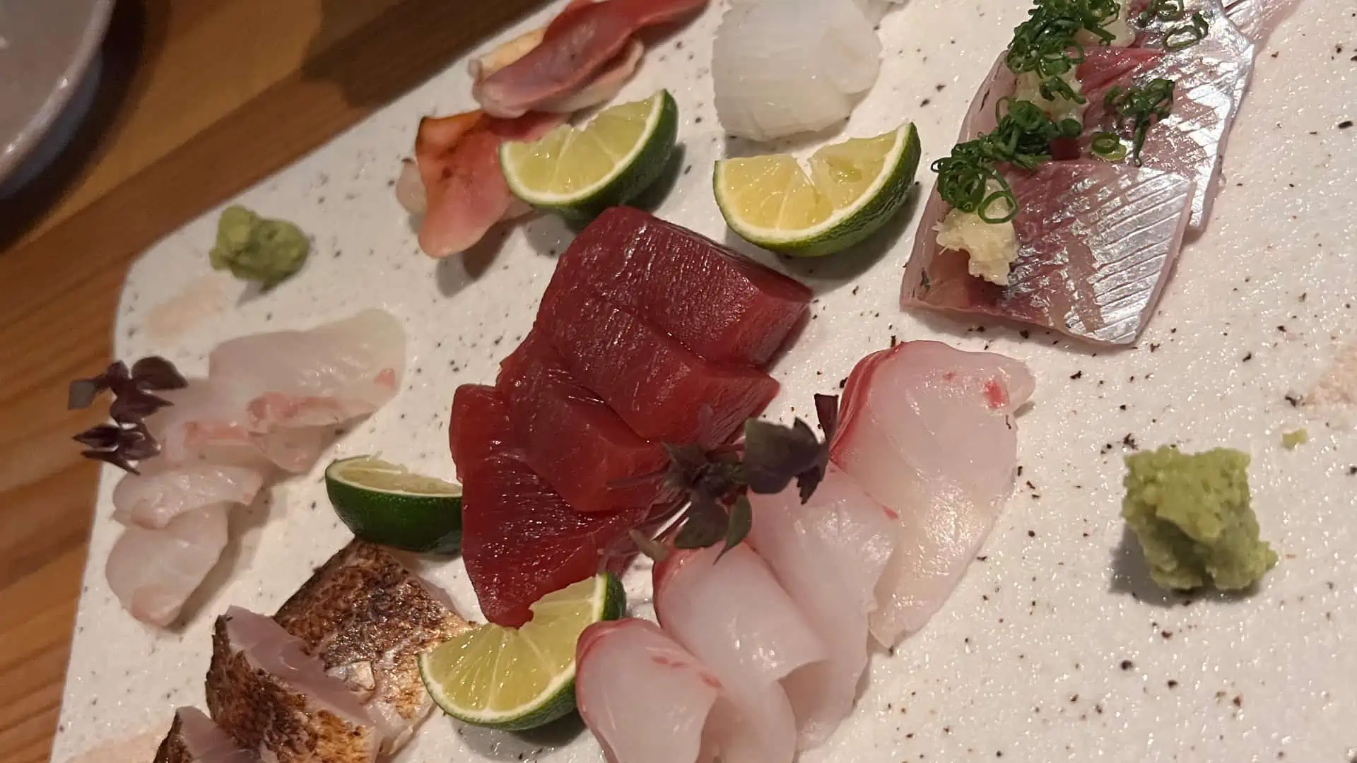 Variety of sashimi served with lime and salt on slab of stone