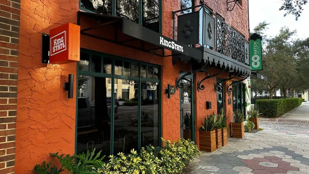 exterior of a cafe with an orange brick facade and wrought iron balconies 