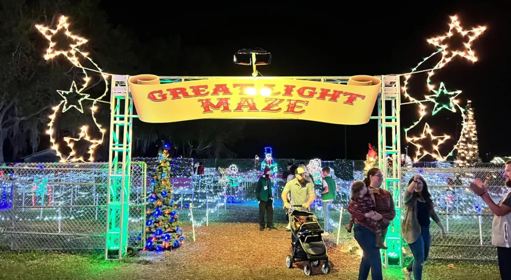 an outdoor light maze with families entering under a bright yellow archway