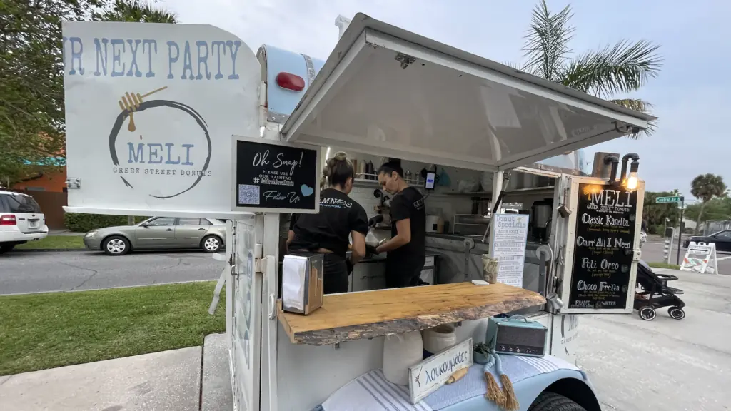 a blue and white Greek donut food cart