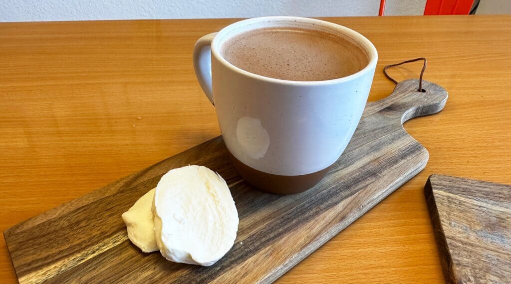 hot chocolate with a small wheel of cheese on the side