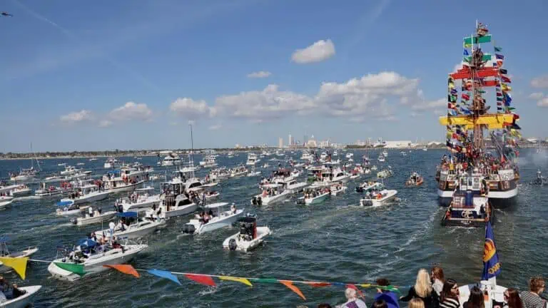 a fleet of ships guided by a large pirate ship sails in tampa