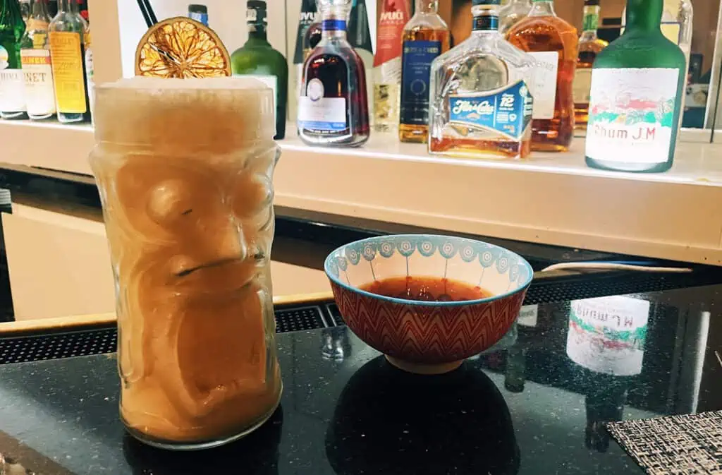 a cocktail in a tiki glass on a counter