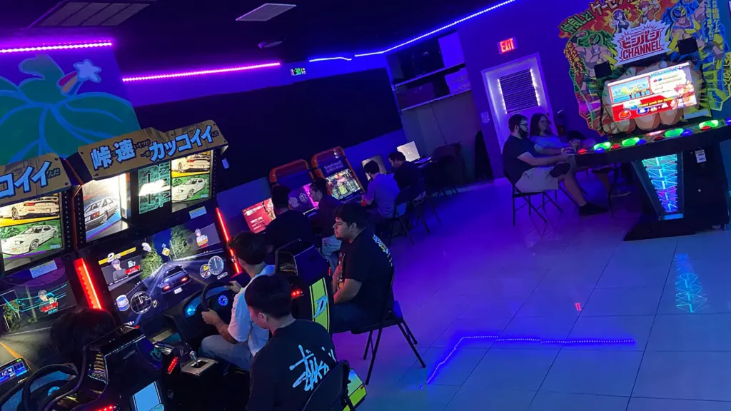 people enjoying racing games inside an arcade