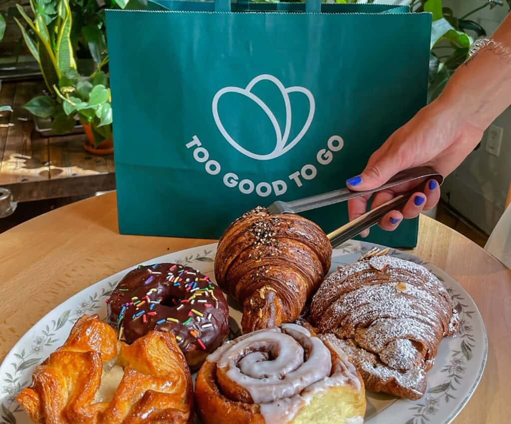 an array of pastries on a plate next to a green bag
