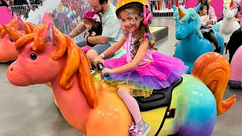 a young kid riding a motorized unicorn