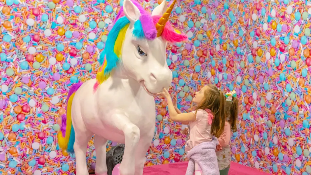 a giant unicorn against a floral wall
