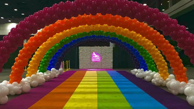 a large rainbow carpet with rainbow balloon archways