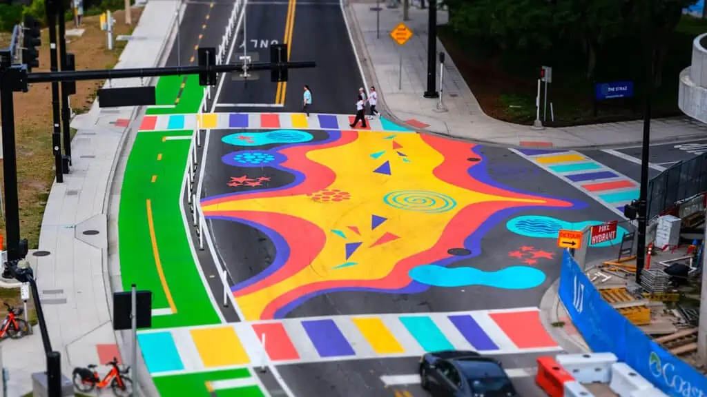 a painted intersection with a green protected bike lane going over a bridge