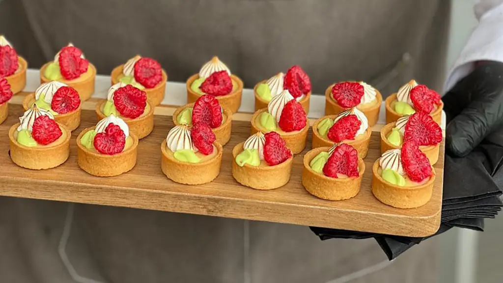 multiple fruit tarts arranged on a wooden board