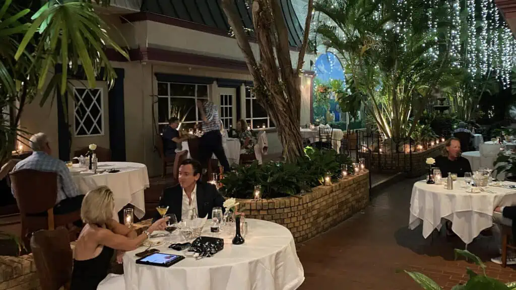 guests enjoy dinner under an ivy wall