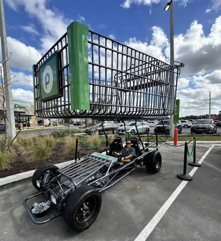 a giant shopping cart in a parking lot of a grocery store