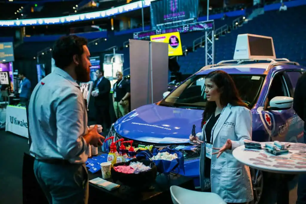 a person stands in front of  smart car with a coffee display in front of a table