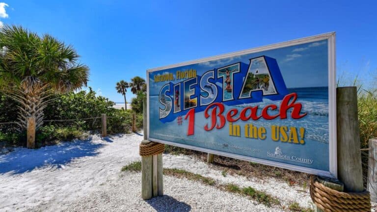 a large blue sign at the entrance to a beach