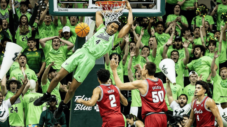 a man in a green jersey dunks a basketball