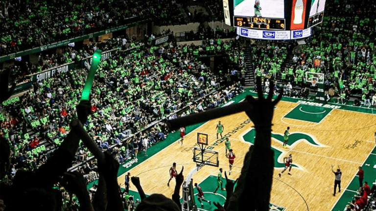 inside a packed basketball stadium with fans cheering