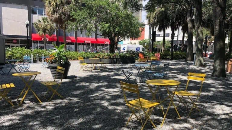 a park with yellow tables set up