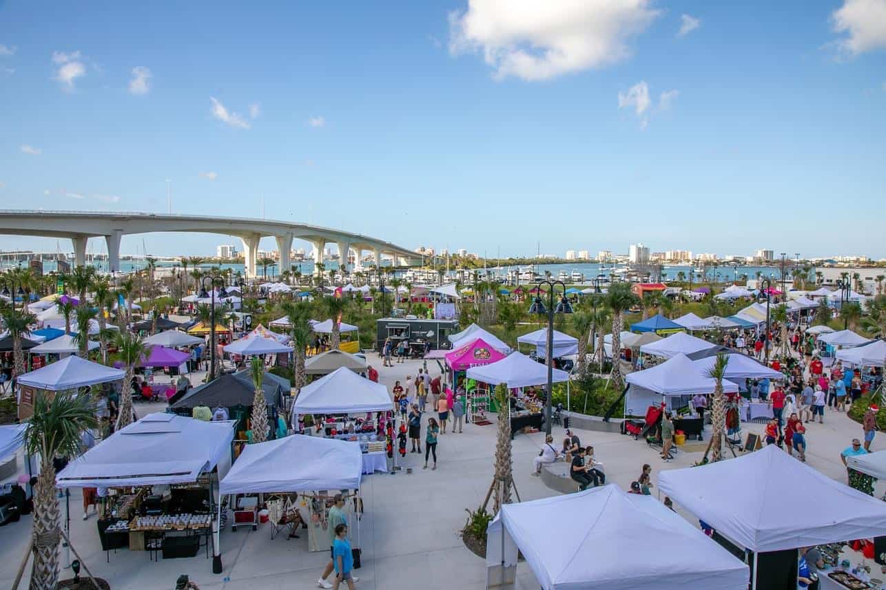 multiple vendor tents arranged on a lawn at a waterfront park
