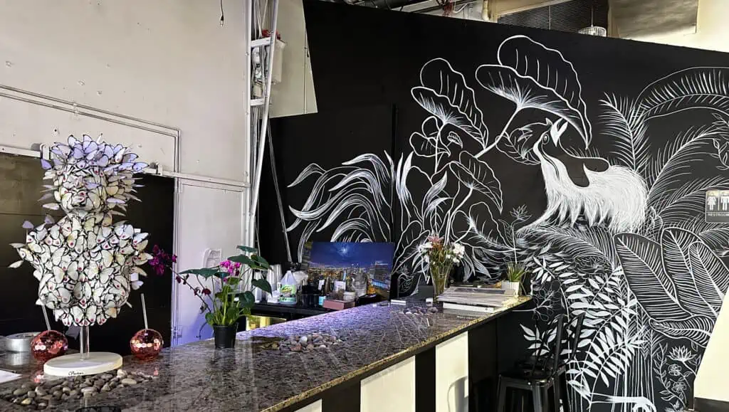 a black marble bar with a mural extending to the back of the bar