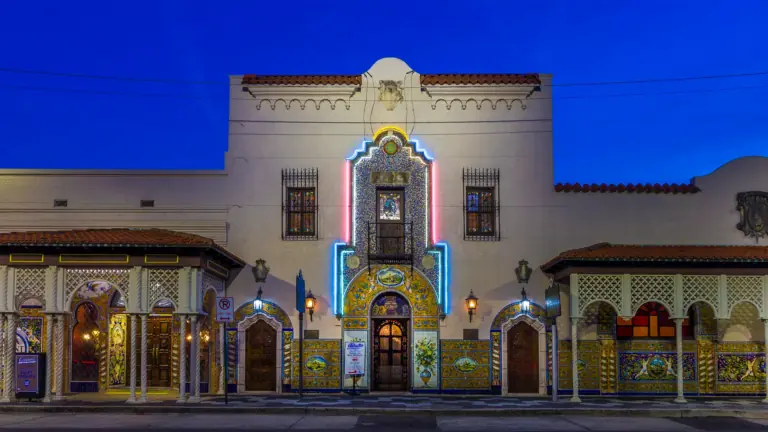 exterior of a restaurant at night. Two neon light tubes flank either side of the front entrance door.