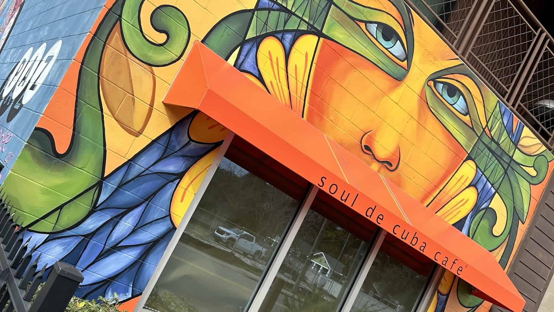 exterior of a restaurant with a big orange and blue mural on the front