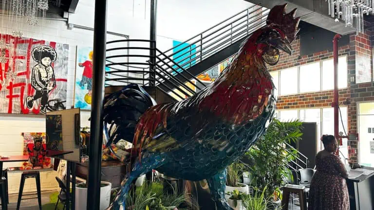 a large rooster sculpture at the front of a restaurant