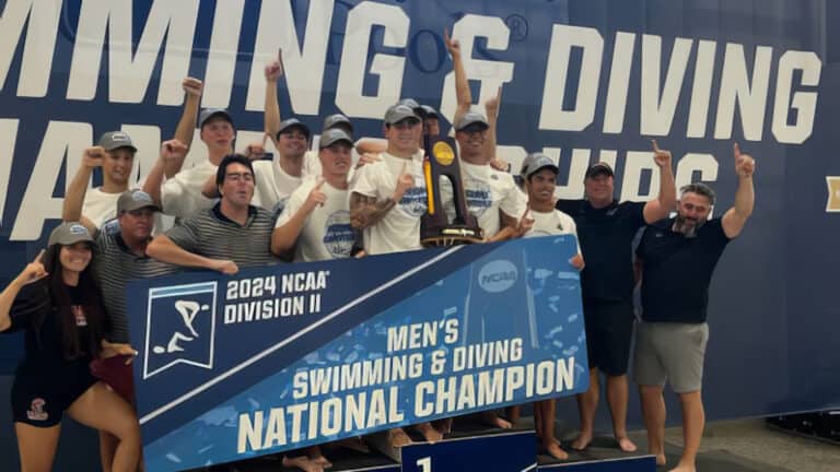 a group of swimmers holding a national championship on a podium