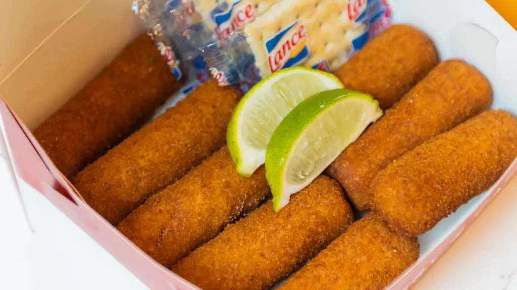 fried croquettes in a box with two lime wedges 