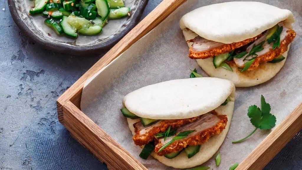 two bao buns filled with chicken and veggies