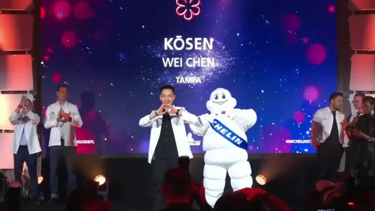 a chef poses on stage with an award at the MICHELIN ceremony