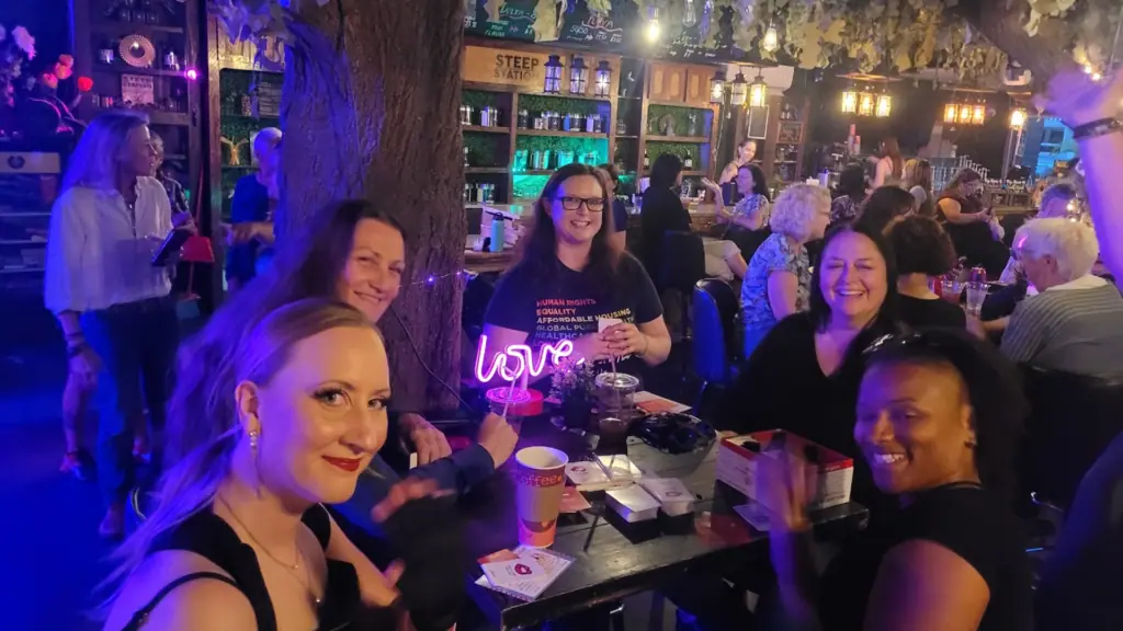 a group of people enjoy live music and drinks at a table at an outdoor bar experience 