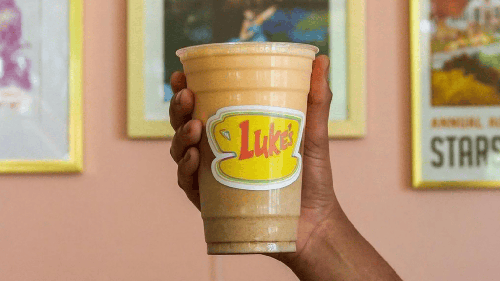 A latte with a yellow label on it reading "Lukes" in red font
