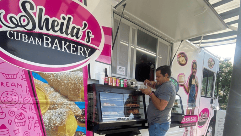 a customer orders food at a white and pink food truck