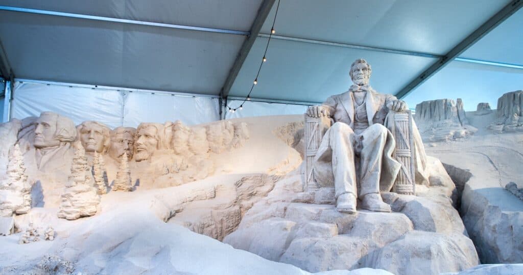 A sand sculpture of Abe Lincoln on display under a tent