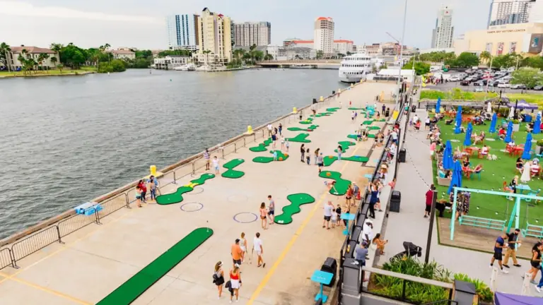 a waterfront mini golf course outside a large dining and shopping destination