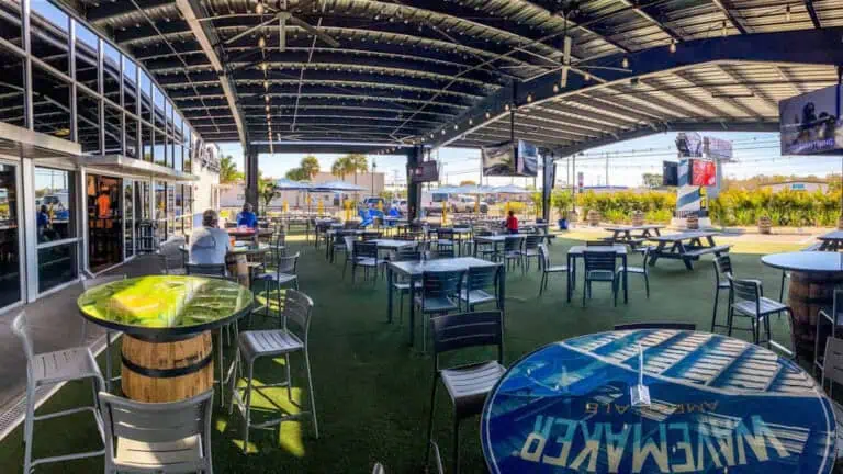 outdoor area of a taproom with multiple tall tables and turf