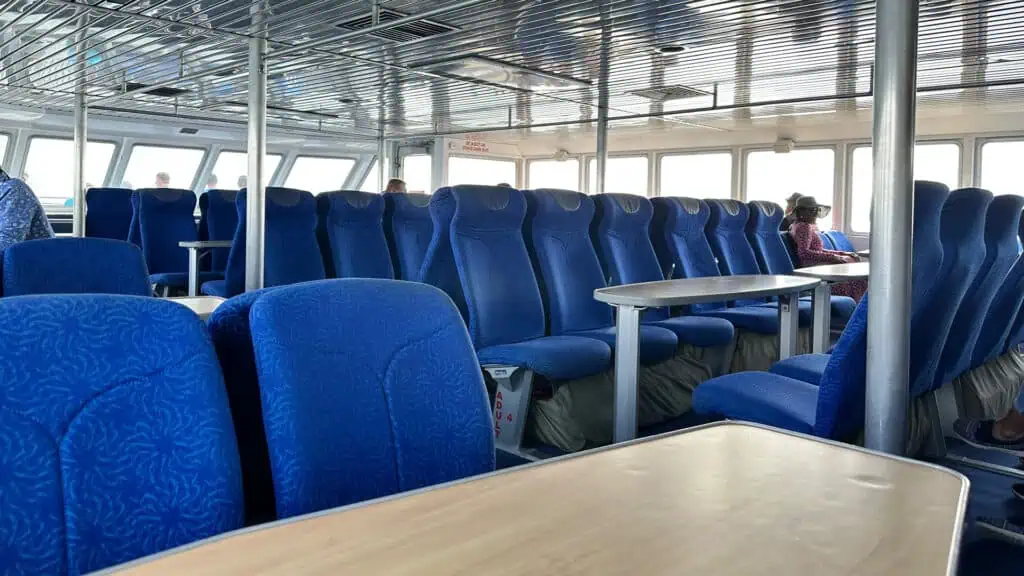 indoor seating on a ferry. The ocean can be see through the far windows 
