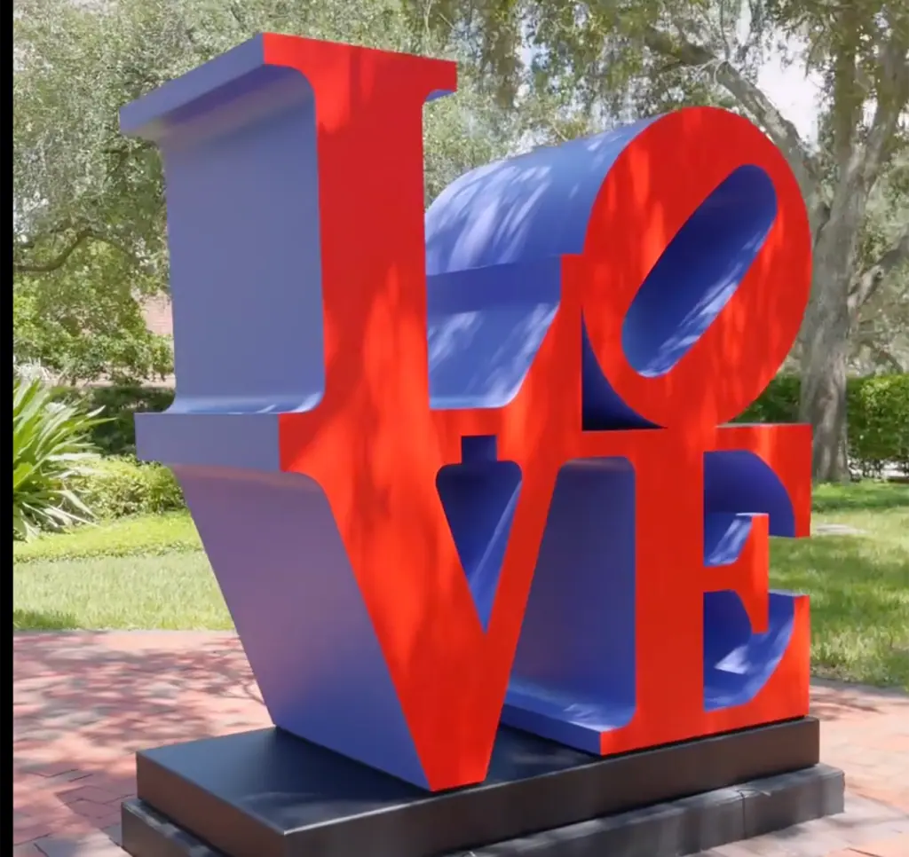 a large red LOVE sculpture on a college campus 