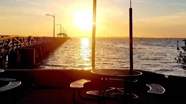 a sunrise view of a long pier