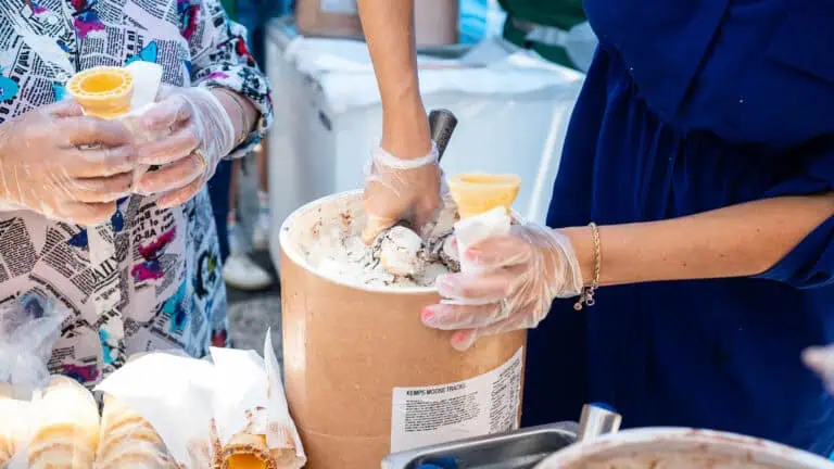 a person scoops moose tracks ice cream at an event