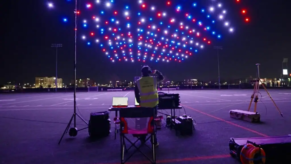 a drone pilot prepares a fleet of drones for a big display in a red white and blue formation