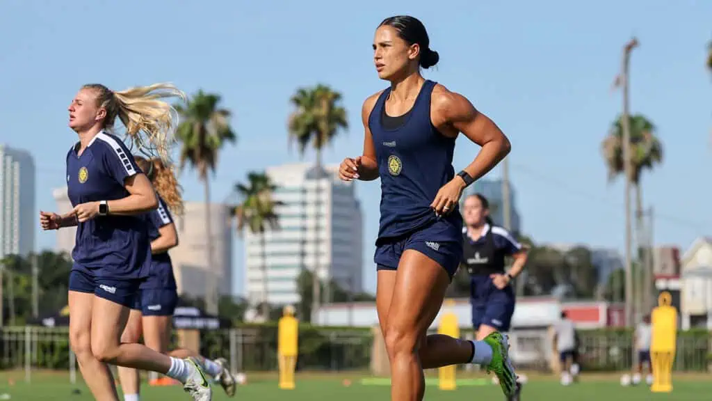 players sprint on the field ahead of a soccer practice