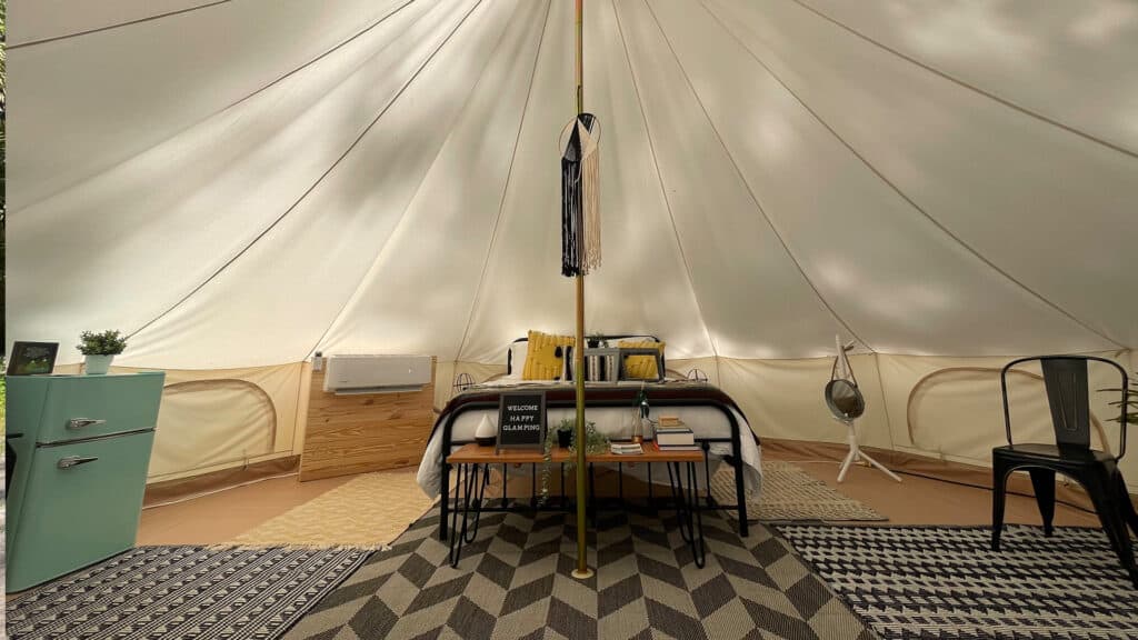 interior of a luxurious tent with a bed at the center